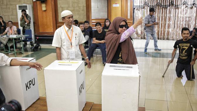 Penyandang disabilitas menunjukkan surat suara saat akan dimasukkan ke dalam kotak ketika simulasi Pemilu di Jakarta, Kamis (14/2). KPU juga berharap surat suara tidak sah bisa berkurang. (Liputan6.com/Faizal Fanani)