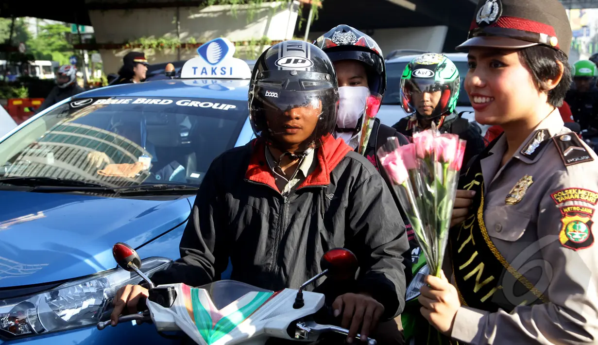 Sejumlah Polisi Wanita (Polwan) membagikan bunga kepada pengendara yang melintas di perempatan Slipi, Jakarta, Selasa (21/4/2015). Pembagian bunga ini dalam rangka memperingati hari Kartini.(Liputan6.com/Johan Tallo)