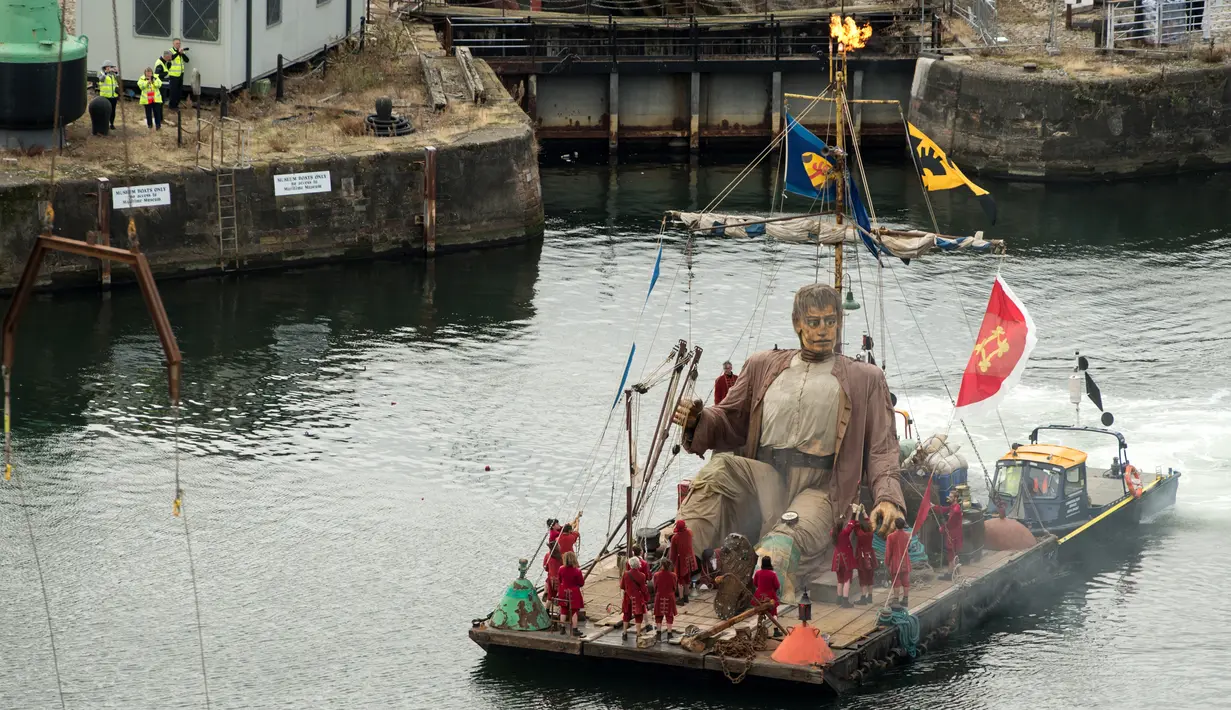 Sebuah boneka besar bernama Giant berbaring di atas rakit melintasi Canning Dock di Liverpool, Inggris, Minggu (7/10). Boneka itu merupakan karya dari kelompok teater jalanan Prancis, Royal de Luxe yang berjudul: Liverpool's Dream (OLI SCARFF/AFP)