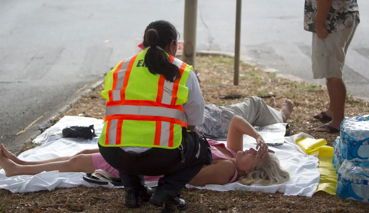 Petugas medis memberi pertolongan kepada korban kebakaran yang terjadi di apartemen Marco Polo, Honolulu (14/7). Setidaknya tiga orang tewas akibat kebakaran yang terjadi di apartemen tersebut. (AP Photo / Marco Garcia)