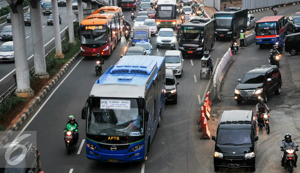Bus APTB melintas di jalur busway di kawasan Gatot Soebroto, Jakarta, Senin (23/5). Dishubtrans DKI Jakarta akan berlakukan larangan APTB beroperasi di jalur Transjakarta mulai 1 Juni mendatang. (Liputan6.com/Yoppy Renato)