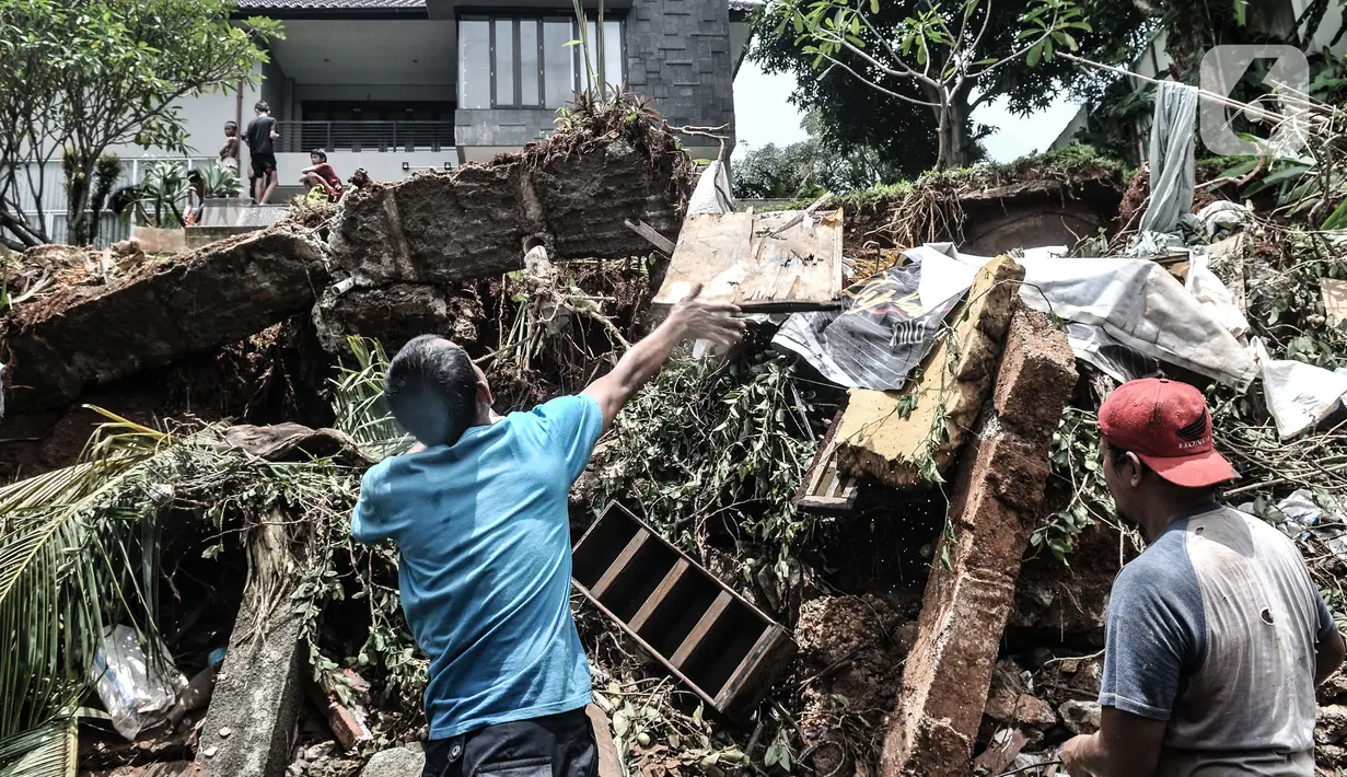 Warga membersihkan puing reruntuhan bangunan pascatanah longsor di kawasan Kemang Timur XI, Jakarta Selatan, Minggu (21/2/2021). Akibat longsor, RT 10 dan 12 RW 03 Kelurahan Bangka hingga kini masih terendam banjir setingi pinggang orang dewasa. (merdeka.com/Iqbal S. Nugroho)