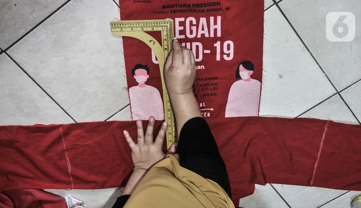 Siti Zahro (44) menyelesaikan pembuatan celemek dari tas bansos Covid-19 di industri jahit rumahan KG-Lupe Fashion, Salemba, Jakarta, Senin (16/11/2020). Siti berinovasi membuat celemek berbahan tas bansos Covid-19 yang didapat dari pemerintah selama PSBB. (merdeka.com/Iqbal S. Nugroho)