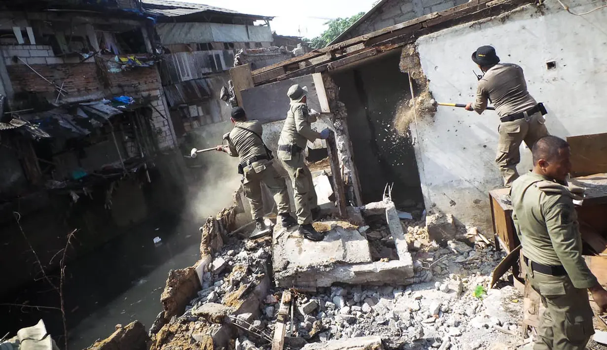 Petugas saat menghancurkan bangunan liar rumah semi permanen di sepanjang bantaran kali Mampang, Jakarta, Senin (18/8/14). (Liputan6.com/Faizal Fanani)