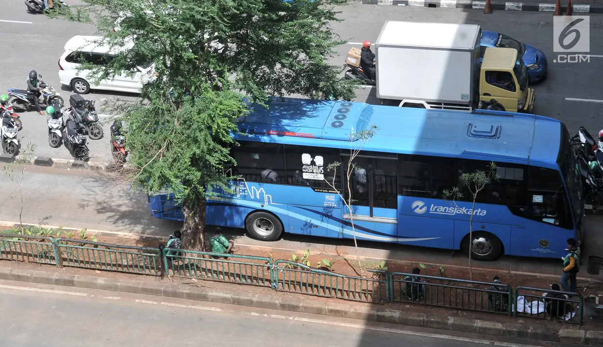 Bus Transjakarta melintasi sepeda motor pengendara ojek online yang terparkir di badan jalan kawasan Mangga Dua, Jakarta, Selasa (23/4). Kurangnya pengawasan dan tidak disiplinnya pengendara ojek online menyebabkan kemacetan kendaraan yang melintas di kawasan tersebut. (merdeka.com/Iqbal S. Nugroho)