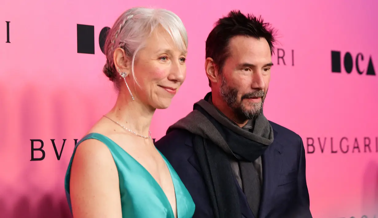 Keanu dan Alexandra membuat para juru foto terpesona dengan penampilan mesra mereka sebelum berbagi ciuman mesra di lobi museum. (Momodu Mansaray/Getty Images/AFP)