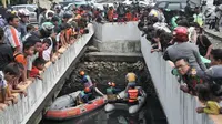 Warga dan pengendara berkerumun melihat upaya tim gabungan melakukan pencarian buaya di Kali Grogol, Jakarta Barat, Kamis (28/6). Pencarian telah dilakukan sejak kemarin siang ketika warga melaporkan penampakan buaya itu. (Merdeka.com/Iqbal S. Nugroho)