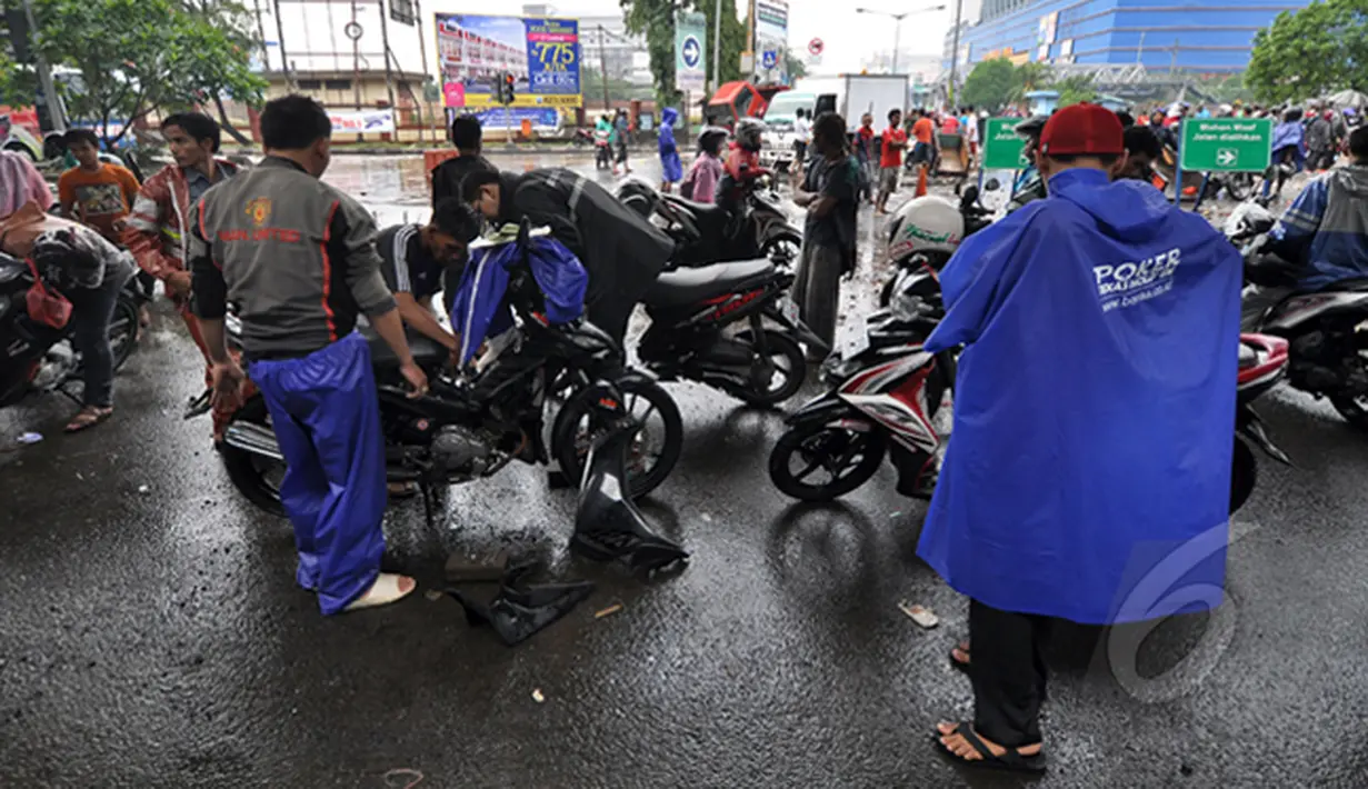 Sejumlah pengendara Motor mencoba menyalakan kendaraannya yang mati akibat menerjang banjir di Jalan Gunung Sahari, Jakarta, Senin (6/2/2015).  (Liputan6.com/Faizal Fanani)