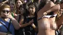 Pengunjuk rasa melepas kausnya saat berpartisipasi dalam unjuk rasa di Ibu Kota Argentina, Buenos Aires, Selasa (7/1). Aksi itu sebagai bentuk protes atas kekerasan yang dilakukan aparat kepolisian terhadap perempuan tanpa bra. (AFP PHOTO/Juan MABROMATA)