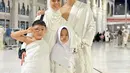 Liburan sekolah, Nycta Gina dan Kinos mengajak kedua anaknya untuk umrah. Putrinya tampil mengenakan kerudung putih yang serasi dengan baju setelannya. [@missnyctagina]