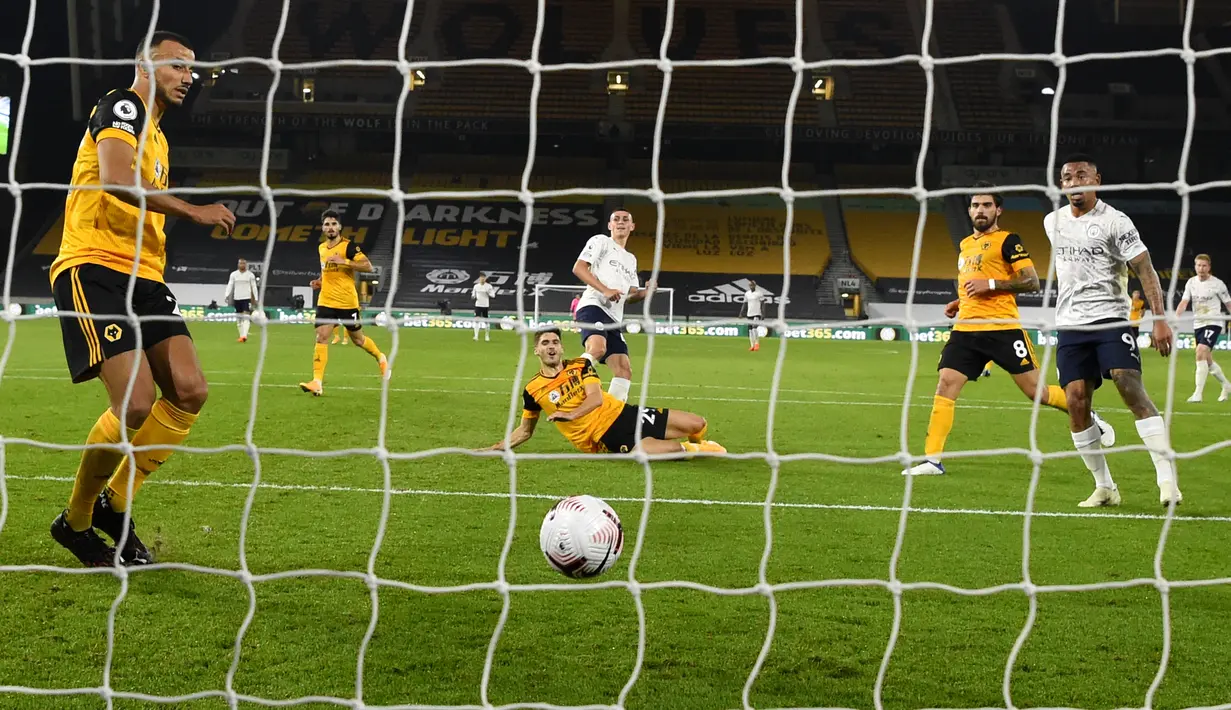 Pemain Manchester City Phil Foden (tengah) mencetak gol ke gawang Wolverhampton Wanderers pada pertandingan Liga Premier Inggris di Stadion Molineux, Wolverhampton, Inggris, Senin (21/9/2020). The Citizens sukses menjinakkan tuan rumah dengan skor 3-1. (Stu Forster/Pool via AP)