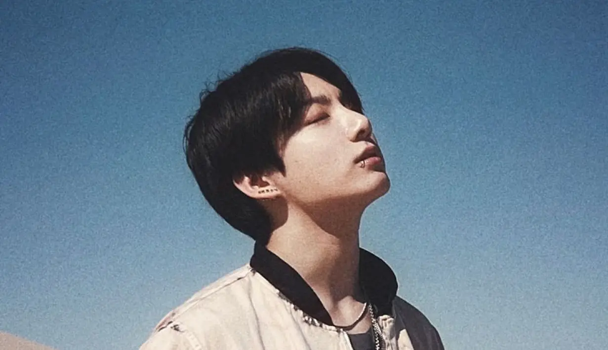 Ini merupakan foto yang diambil saat Jungkook melakukan syuting video musik "Yet To Come" untuk album BTS yang terbaru; PROOF. Di sini, Jungkook tampil kasual dengan bomber jacket bercorak abstrak, untuk melapisi kaus hitam polosnya. Anting, kalung, dan sunglasses melengkapi penampilannya sebagai statement yang menarik. Foto: Instagram.