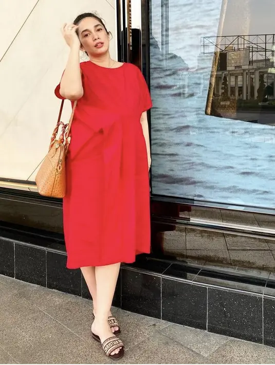 Saat hamil pun Ussy tetap terlihat fashionable dengan dress selutut warna merah. Gaya santainya ini dilengkapi dengan sandal dan sling bag. (Dok. Instagram @ussypratama)