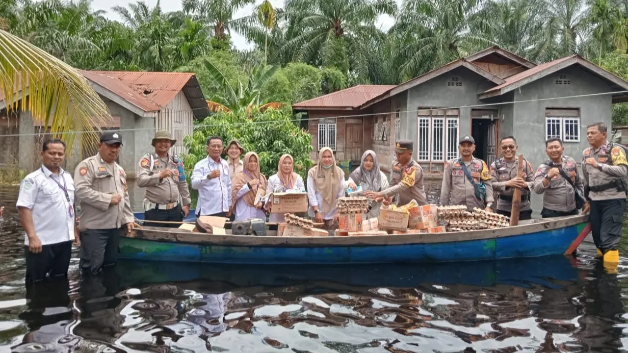 Personel Polres Rokan Hilir bersama pihak terkait membawa bantuan sembako untuk korban bencana banjir.