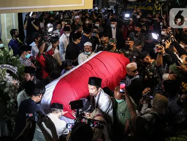 Saudara serta Kerabat mengangkat dan mendorong Peti Jenazah Ketua Dewan Pers Azyumardi Azra di rumah duka di Perumahan Puri Laras II, Cirendeu, Tangerang Selatan, Selasa (20/9/2022) dinihari. Azyumardi Azra meninggal dunia pada Minggu (18/9/2022) di rumah sakit Kedah, Selangor, Malaysia pukul 12.30 waktu setempat, dan rencana akan dimakamkan Selasa (20/9/2022) di Taman Makam Pahlawan (TMP) Kalibata. (Liputan6.com/Johan Tallo)