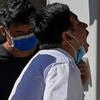 Seorang pria membuka maskernya untuk melakukan swab tenggorokan COVID-19 secara rutin di tempat pengujian virus corona di Beijing, Selasa (6/9/2022). Saat ini ada 33 kota di China yang berada dalam situasi lockdown sebagian atau penuh karena wabah COVID-19. (AP Photo/Andy Wong)
