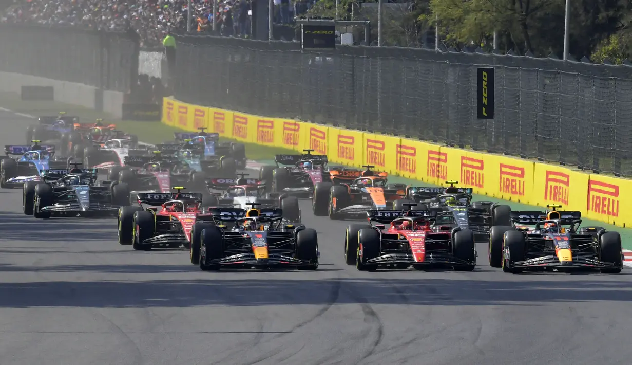 Pembalap Red Bull, Sergio Perez (kanan) memacu mobilnya saat start Formula 1 GP Meksiko 2023 yang berlangsung di Sirkuit Hermanos Rodriguez, Meksiko, Minggu (30/10/2023) dini hari WIB. (AFP/Claudio Cruz)