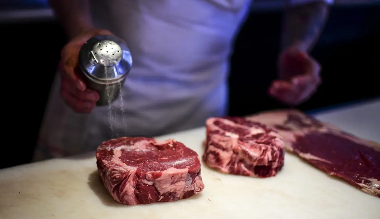 Seorang koki menyiapkan potongan daging untuk dimasak di dapur restoran Don Julio di lingkungan Palermo, Buenos Aires, Argentina, Kamis (20/5/2021). Konsumsi daging sapi di Argentina alami penurunan terendah terkait situasi ekonomi dan inflasi yang mencapai 17,6 persen. (RONALDO SCHEMIDT/AFP)
