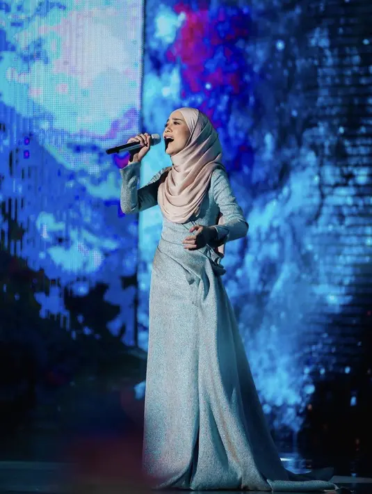 Sesekali Lesti pun kembali bernyanyi di atas panggung mengenakan dress lengan panjang warna biru dipadukan kerudung coklatnya. (@lestykejora)