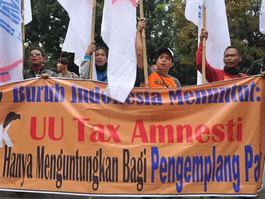 Ratusan buruh dari Konferederasi Serikat Pekerja Indonesia menggelar unjuk rasa di depan Mahkamah Konstitusi, Jakarta, Jumat (22/7). Mereka mengajukan berkas gugatan uji materi atas UU Pengampunan Pajak (Tax Amnesty). (Liputan6.com/Gempur M Surya)