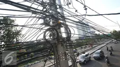Instalasi kabel saling bersinggungan di tiang Jalan Gunung Sahari, Jakarta, Rabu (13/7). Kurangnya penataan membuat instalasi kabel di Ibu Kota terlihat semrawut dan mengganggu pemandangan. (Liputan6.com/Immanuel Antonius)