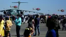 Tim aerobatik Angkatan Udara India, Sarang, terbang dalam formasi melewati Embraer C-390 Millennium Angkatan Udara Brasil pada hari keempat Aero India 2023 di pangkalan udara Yelahanka, Bengaluru, India, 16 Februari 2023. Aero India adalah acara dua tahunan dengan demonstrasi terbang oleh tim stunt dan militer serta komersial paviliun tempat perusahaan penerbangan memamerkan produk dan teknologinya. (AP Photo/Aijaz Rahi)
