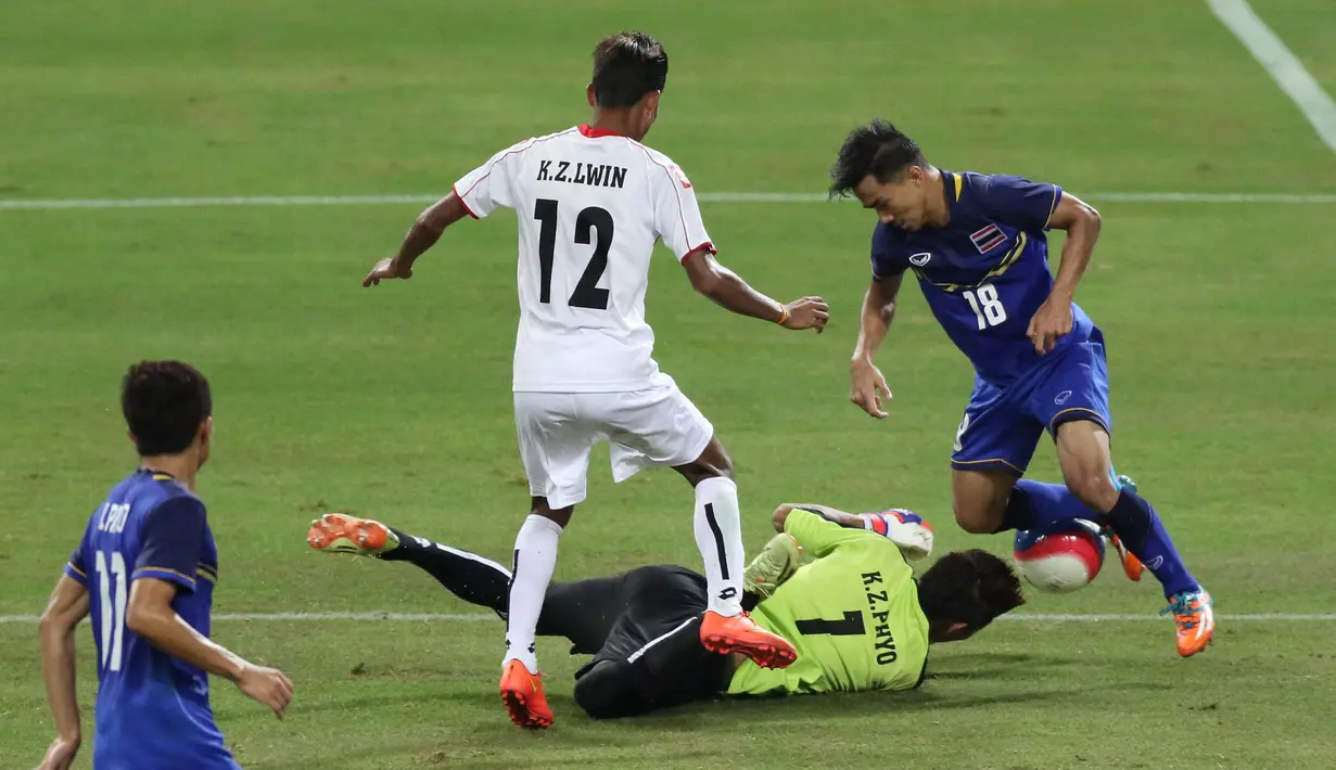 Pemain Thailand U-23 berebut bola dengan pemain Myanmar U-23 dalam final sepak bola SEA Games 2015. (Bola.com/Arief Bagus)