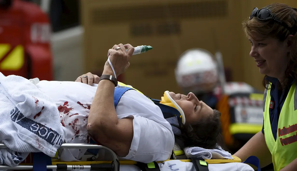 Petugas membawa penumpang bus yang tertabrak jembatan untuk dirawat di Australia (22/2). Bus wisata yang membawa 19 penumpang tersebut menabrak pembatas kolong jembatan yang memiliki tinggi 10 kaki (3 meter). (REUTERS/Mal Fairclough)