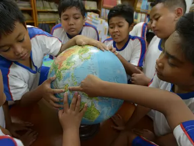 Sejumlah siswa mencari lokasi calon ibu kota baru pada globe saat kegiatan belajar bertema wawasan Nusantara di SDN Menteng 02, Jakarta, Selasa (27/8/2019). Kegiatan belajar wawasan Nusantara itu memberitahukan lokasi pemindahan ibu kota RI dari Jakarta ke Kalimantan Timur.(merdeka.com/Imam Buhori)