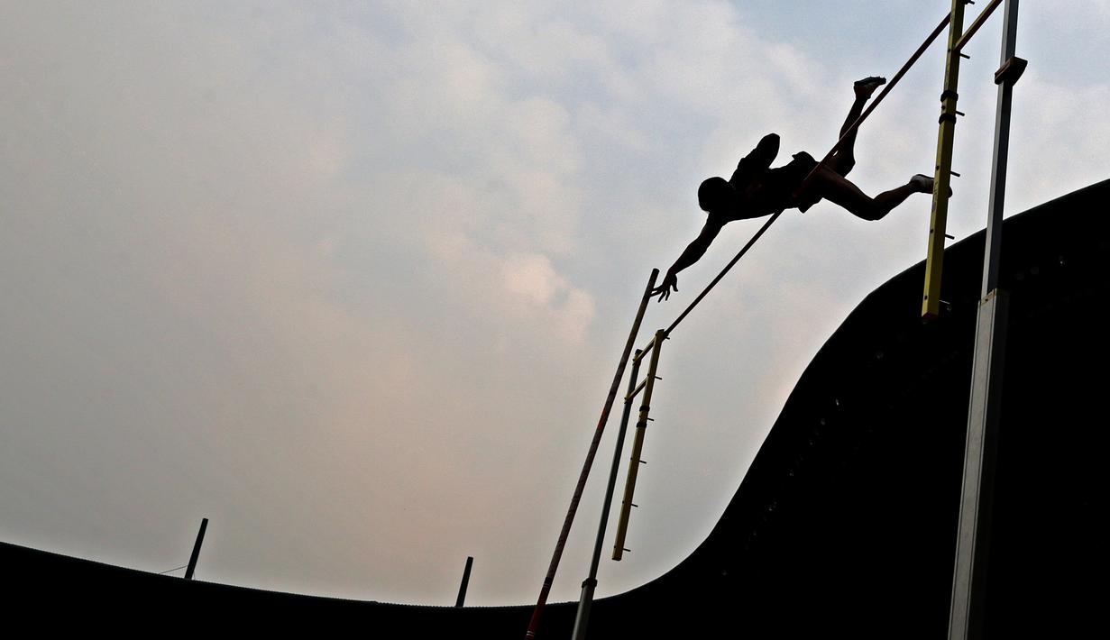 Seorang atlet melakukan lompatan saat Kejurnas Atletik nomor lompat tinggi galah senior putra di Stadion Pakansari, Bogor, Selasa (6/8). Kejurnas tahun ini juga dilakukan untuk kualifikasi jelang PON. (Bola.com/Peksi Cahyo)