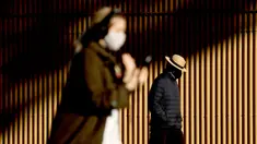 Orang-orang berjalan di sepanjang Circular Quay, Sydney, Australia, Selasa (13/7/2021). Lima juta penduduk Sydney akan berada dalam lockdown COVID-19 untuk dua minggu lagi. (Brendon THORNE/AFP)