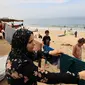 Seorang perempuan Palestina menggantung cucian yang dicuci menggunakan air laut karena kurangnya air bersih dan listrik di sepanjang pantai di Deir el-Balah di selatan Jalur Gaza, di tengah pertempuran yang sedang berlangsung antara Israel dan kelompok Palestina Hamas. pada 29 Oktober 2023. (MAHMUD HAMS / AFP)