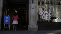 Seorang perempuan muda memasuki toko yang mengiklankan obral di Regent Street di London, Rabu (16/11/2022).  Inflasi Inggris menembus 11,1 persen pada bulan Oktober 2022 dan mencapai rekor tertinggi sepanjang 41 tahun. (AP Photo/Alastair Grant)