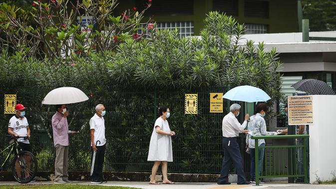 Para pemilih mengenakan masker dan menerapkan jaga jarak aman saat akan memberikan suara dalam pemilu di TPS Sekolah Dasar Alexandra, Singapura, Jumat (10/7/2020). Pemilu di tengah pandemi COVID-19, warga Singapura memberikan suaranya dengan mengenakan masker dan sarung tangan plastik. (AP Photo)