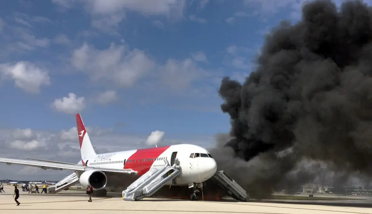 Kepulan asap keluar dari pesawat Boeing 767-200ER milik maskapai Dynamic International Airways yang terbakar saat akan lepas landas di Bandara Fort Lauderdale, Florida, Kamis (29/10). 15 orang terluka akibat kejadian tersebut. (AFP PHOTO/Andres Gallego)