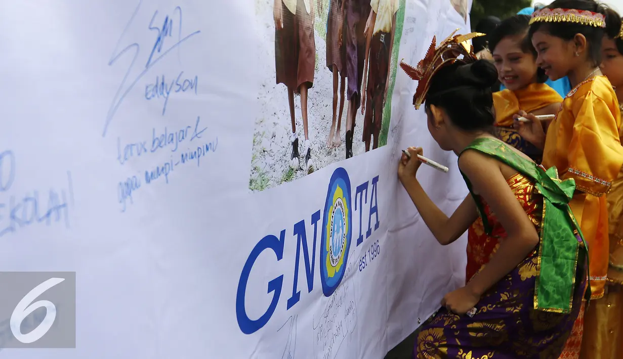 Sejumlah anak menuliskan testimoni saat Festival Anak Asuh di Car Free Day, Jakarta, Minggu (1/11/2015). Festival ini diikuti 200 lebih anak asuh dari SDN Kebon Sirih. (Liputan6.com/Yoppy Renato)