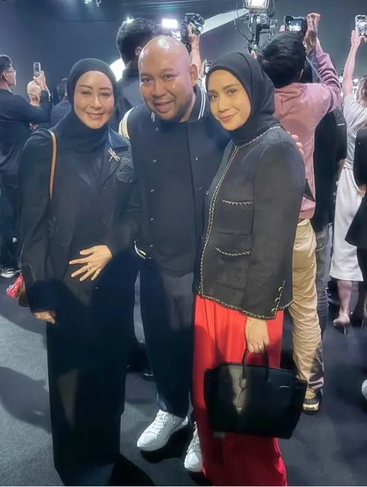 Nagita Slavina mengenakan blazer hitam model tweed, dipadukan kerudung warna senada dan celana panjang merah. [@raffinagita1717]