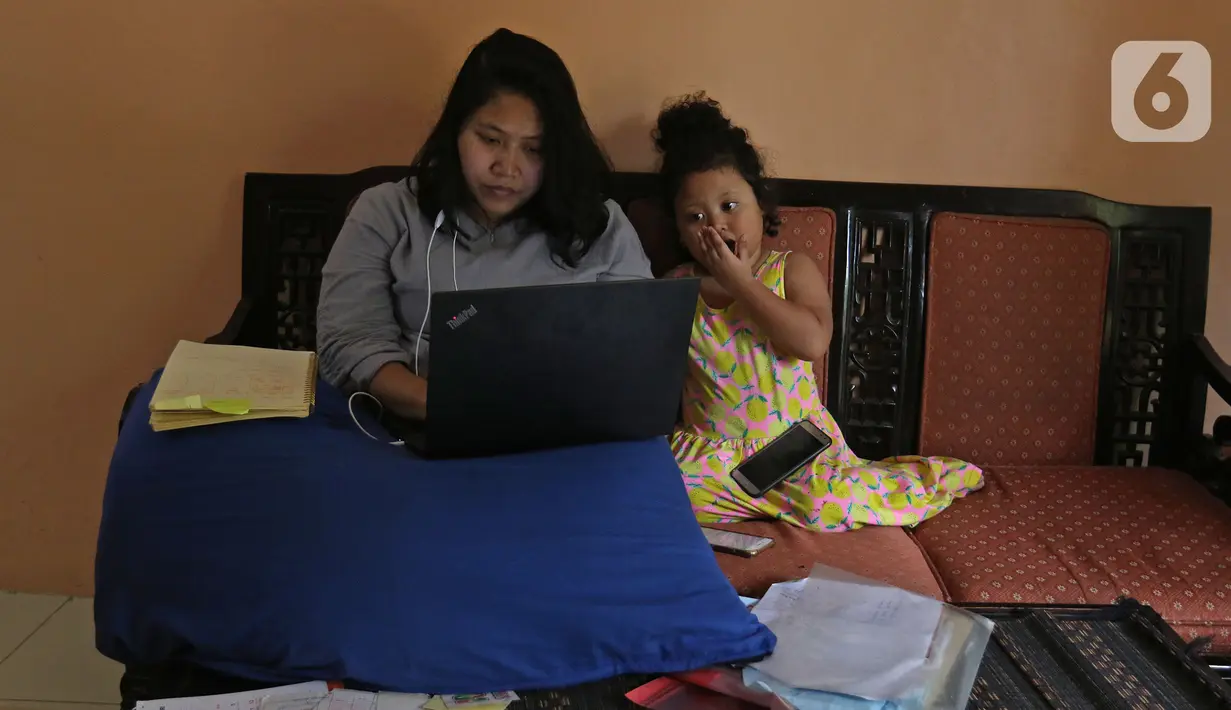 Karyawan swasta sedang koordinasi lewat video call saat kerja dari rumah di kediamannya kawasan Depok, Jawa Barat, Senin (23/3/2020). Keputusan Gubernur DKI Jakarta Anies Baswedan anjuran kerja dari rumah dimulai sejak 20 Maret hingga 2 April 2020. (Liputan6.com/Herman Zakharia)