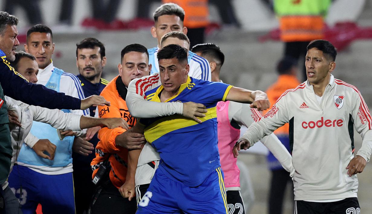 Pemain River Plate berusaha menenangkan pemain Boca Junior, Miguel Merentiel (tengah) setelah insiden keributan yang terjadi dalam pertandingan Argentine Professional Football League Tournament 2023 yang berlangsung di El Monumental stadium, Senin (8/5/2023) pagi WIB. (AFP/Alejandro Pagni)