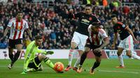 Kiper MU, David de Gea, berusaha menahan serangan pemain Sunderland, Jermain Defoe, dalam laga Liga Inggris di Stadium of Lights, Sunderland, Sabtu (13/2/2016) malam WIB. (AFP/Oli Scarff)