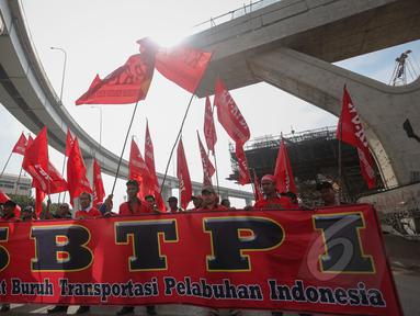 Sejumlah Massa yang tergabung dalam Federasi Serikat Buruh Transportasi Pelabuhan Indonesia (FSBTPI) melakukan long march dari Kawasan Pelabuhan Tanjung Priok menuju Istana Merdeka, Jakarta, Jumat (1/4/2015). (Liputan6.com/Faizal Fanani)