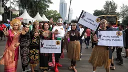 Satgas saber pungli mengenakan kostum super hero dan tradisional berfoto bersama saat mensosialisasikan tolak pungli di Car Free Day, Jakarta, Minggu (12/11). (Liputan6.com/Faizal Fanani)