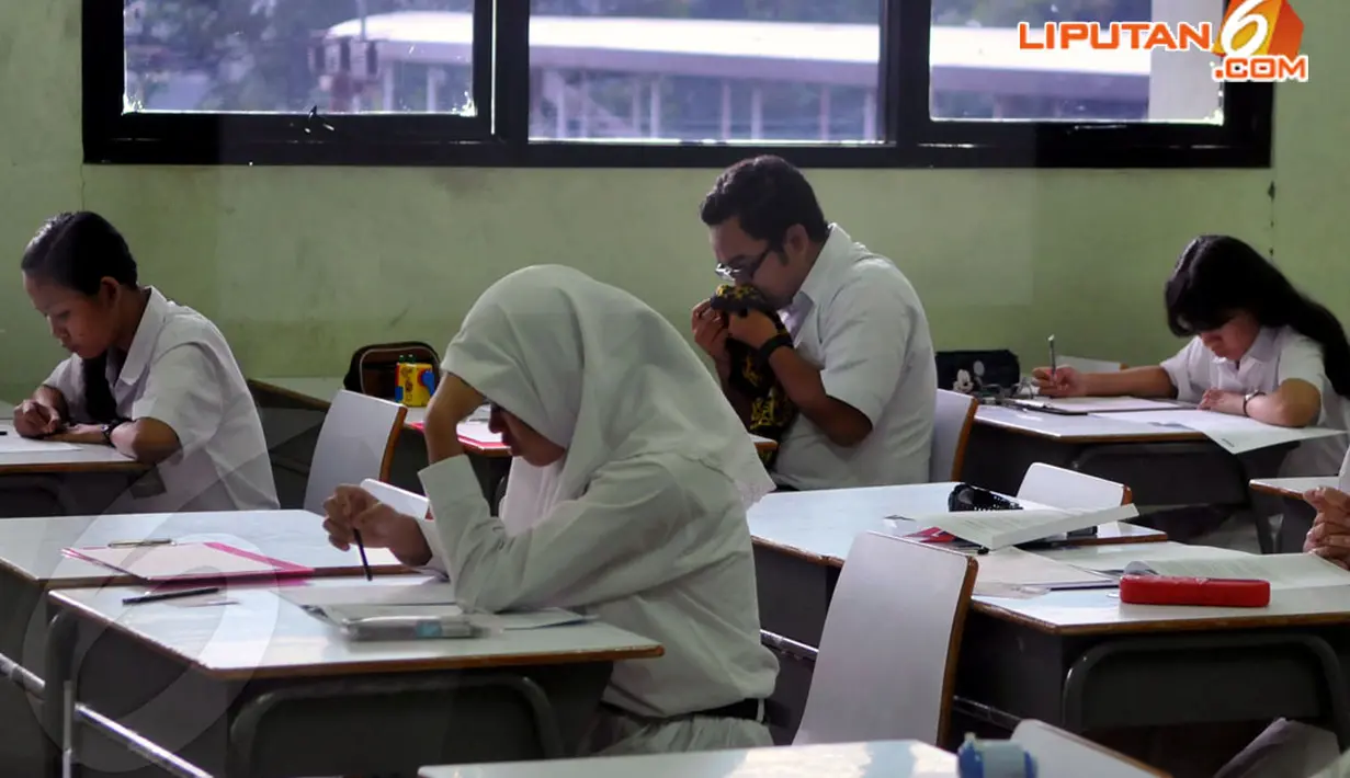 Para siswa SMA 112 Jakarta terlihat serius mengerjakan soal-soal ujian nasional pada Senin (14/4/2014). (Liputan6.com/Johan Tallo)