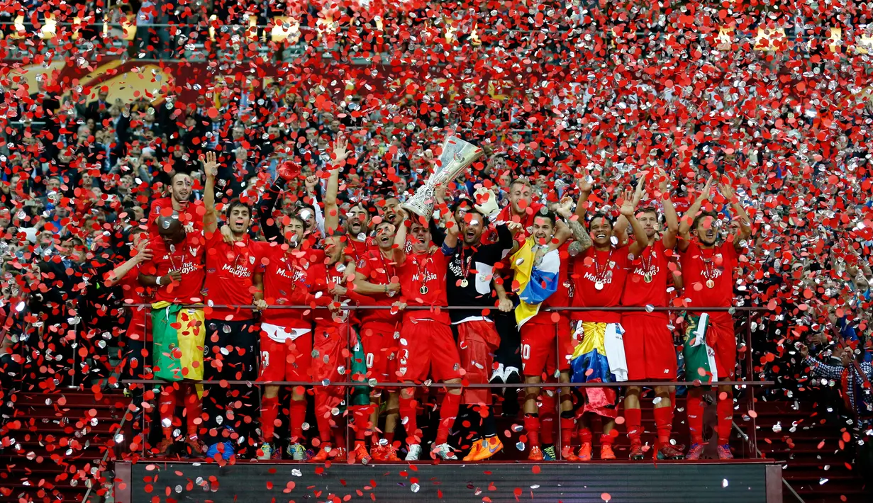 Para pemain Sevilla bergembira mengangkat trofi juara Liga Europa 2015 usai mengalahkan Dnipro di final di Stadion Narodowy, Polandia, Kamis (28/5/2015). Sevilla memecahkan rekor meraih trofi Liga Europa terbanyak, yakni empat gelar. (Reuters/Carl Recine)