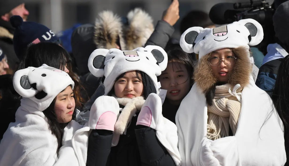 Sejumlah penonton wanita mengenakan atribut unik ketika menyaksikan cabang snowboard putri pada Olimpiade Musim Dingin 2018 di PyeongChang, Korea Selatan, Senin (12/2). Olimpiade PyeongChang berlangsung hingga 25 Februari mendatang. (OIC VENANCE/AFP)