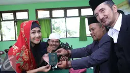 Ria Irawan berpose menunjukan buku nikah seusai Ijab Qabul di KUA Cilandak, Jakarta, Jumat (23/12). Sebelumnya, Ria Irawan sudah pernah menikah dengan seorang pengusaha bernama Yuma Wiranatakusumah pada 1997 silam. (Liputan6.com/Herman Zakharia)
