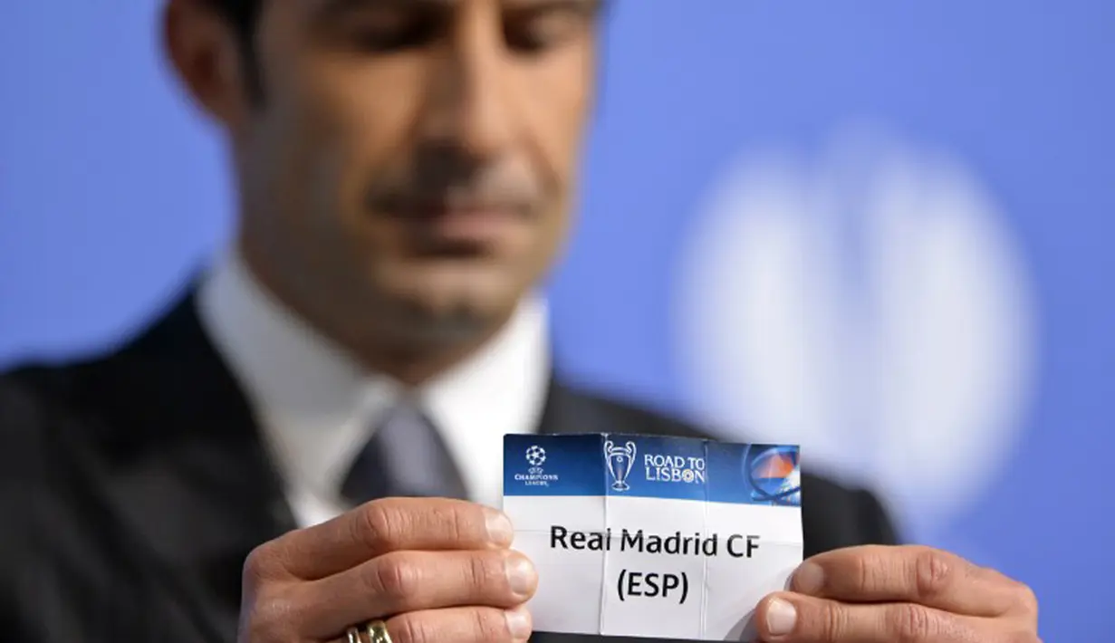 Luis Figo sedikit tertegun memegang kartu draw yang bertuliskan nama mantan   klubnya, Real Madrid, saat undian laga semifinal Liga Champions di markas UEFA di Nyon   pada Jumat 11 April 2014. (AFP PHOTO/FABRICE COFFRINI)