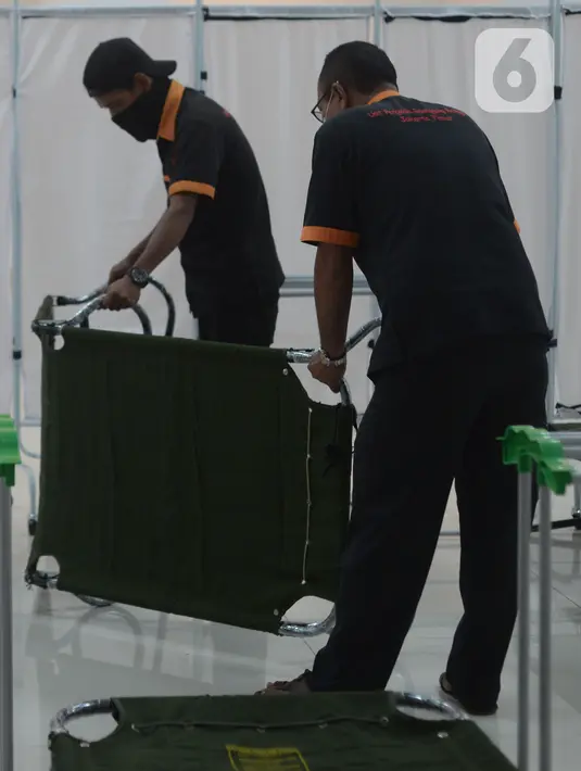 Petugas menyiapkan sarana tempat isolasi mandiri (isoman) untuk pasien Covid-19 di Gelanggang olahraga (GOR) Matraman, Jakarta Timur, Rabu (14/7/2021). Sebanyak 30 velbed disiapkan bagi pasien dengan status orang tanpa gejala (OTG) hingga gejala ringan. (merdeka.com/Imam Buhori)