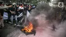 Massa yang tergabung dalam gerakan nasional tolak reklamasi (Gentar) membakar ban saat aksi didepan Gedung Balaikota, Jakarta, Rabu (8/7/2020). Reklamasi Pantai Ancol dianggap sebagai bentuk perampasan pantai publik atas akses masyarakat nelayan pesisir Jakarta.  (Liputan6.com/Faizal Fanani)