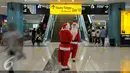 Dua Santa Claus saat ingin memberikan hadiah kepada penumpang di Bandara Soekarno Hatta, Tangerang, Banten, Selasa (22/12). Sejumlah orang berkostum santa claus membagikan coklat kepada penumpang yang berada dibandara. (Liputan6.com/Faisal R Syam)